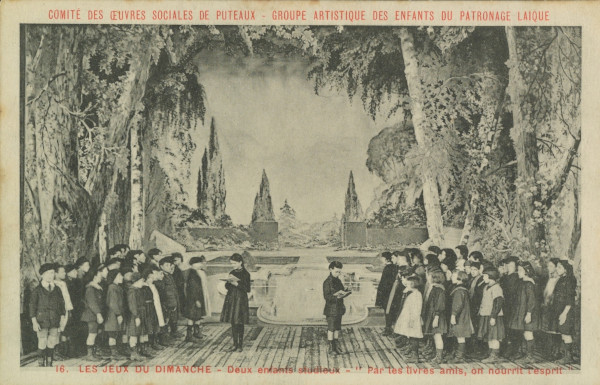 Carte postale ancienne représentant une photo de la représentation "Les jeux du dimanche" : "Deux enfants studieux - Par les livres amis, on nourrit l'esprit".
